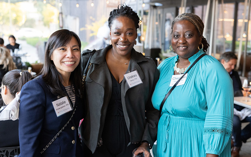 Three females standing side by side looking into the camera and smiling