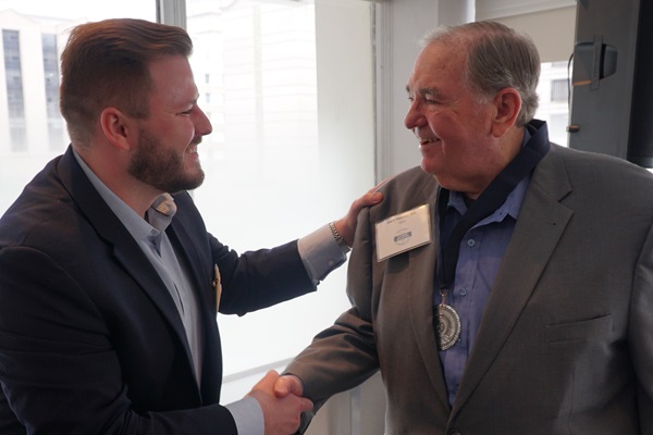 Student and mentor shaking hands at a volunteer event