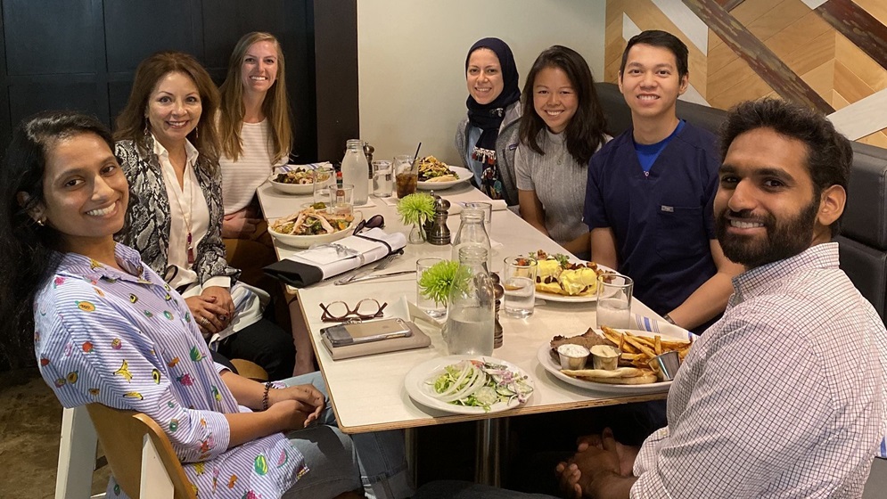 Group of medical students having dinner with a McGovern Medical School alumnus