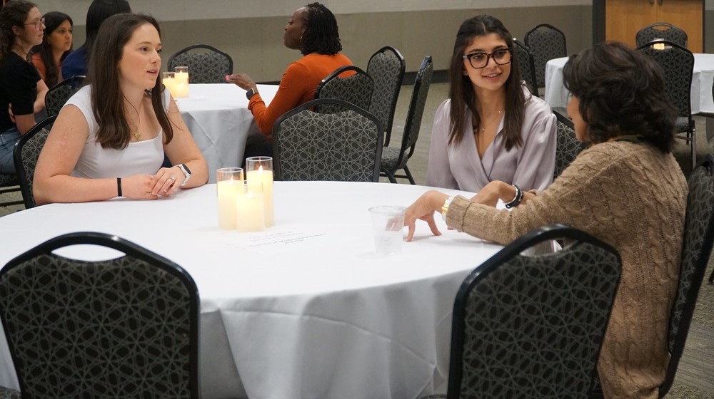 Three women sitting at a table having a conversation