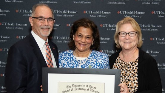 Dr. Rena D’Souza (middle) is presented her UTHealth Houston School of Dentistry Alumni Lifetime Achievement Award by Dr. John Valenza (left), dean, and Dr. Mary (Cindy) Farach-Carson, associate dean of research